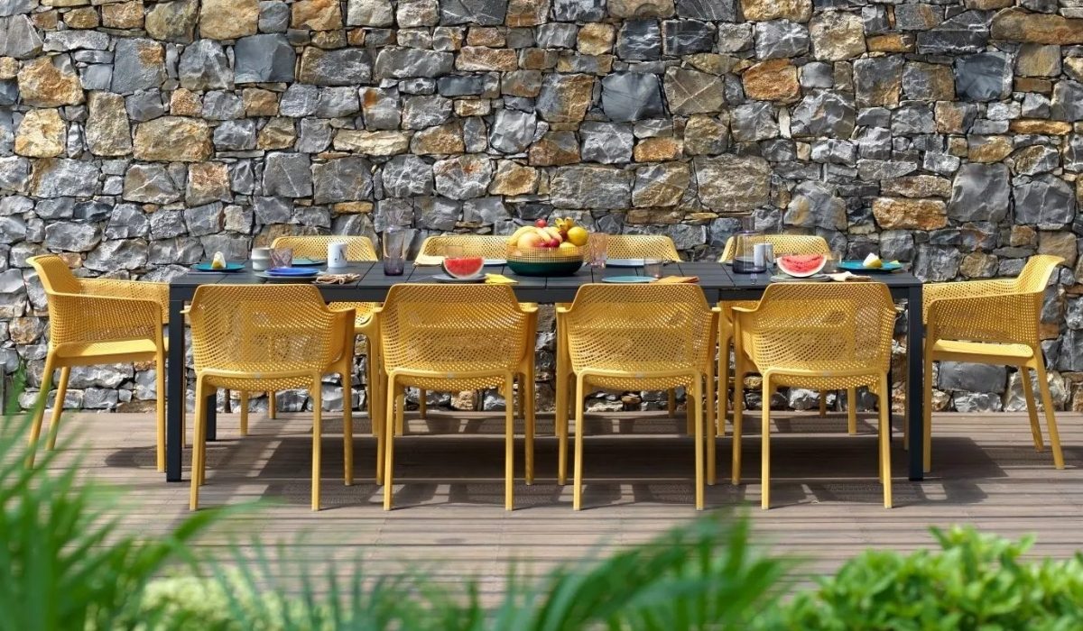 Großer Gartentisch mit gelben Gartenstühlen von NARDI