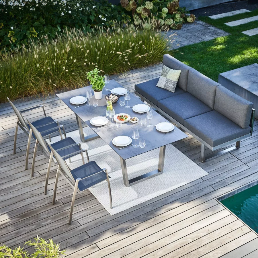 Moderner Kufen-Gartentisch mit drei Gartenstühlen und einer gepolsterten Gartenbank in Dining-Höhe