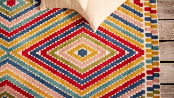 Bunter Outdoor-Teppich und Kissen auf Terrassenboden