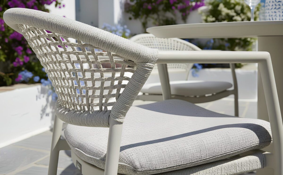 Nahaufnahme eines Gartenstuhls mit Rope-Geflecht am Rücken und bequemem Sitzkissen