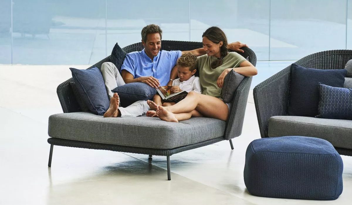 Familie kuschelt sich entspannt auf einem Daybed zusammen.