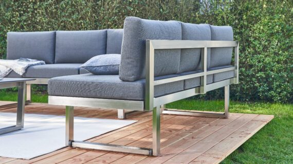 Rückansicht eines Loungesofas auf einer Holzplattform im Garten