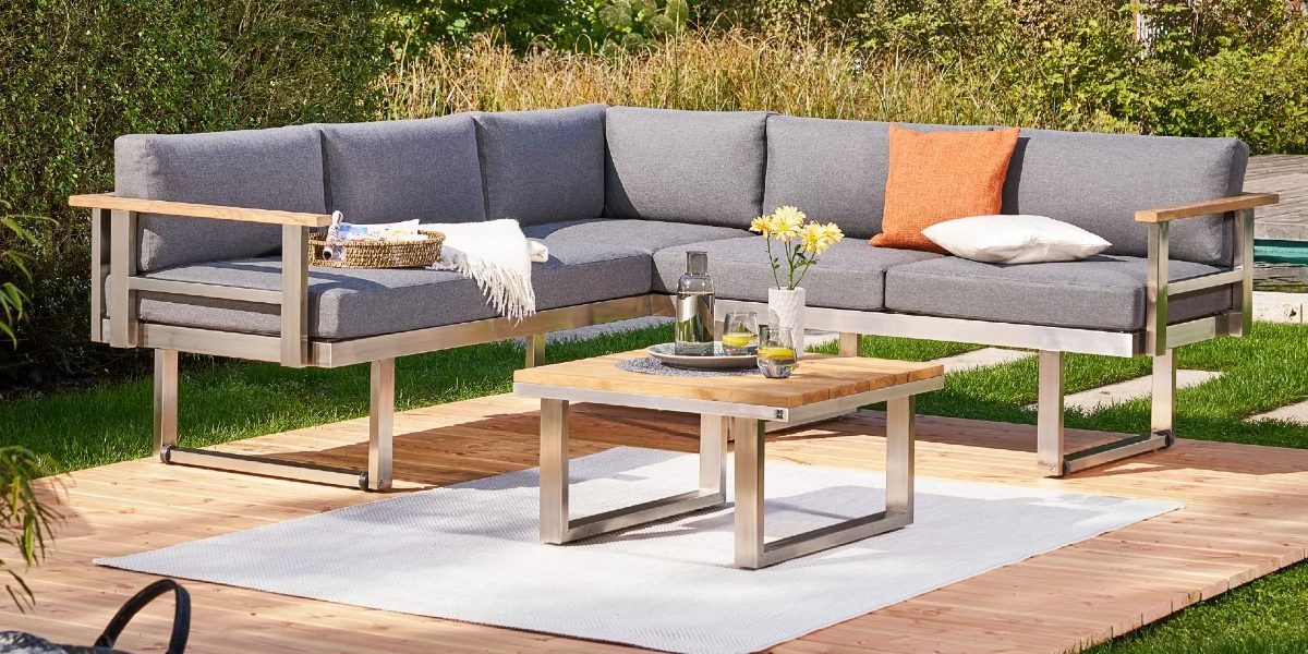 Ecklounge aus gebürstetem Edelstahl kombiniert mit einem Loungetisch mit Teakholzplatte